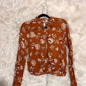 Blouse with flowers and a little open triangle in the middle